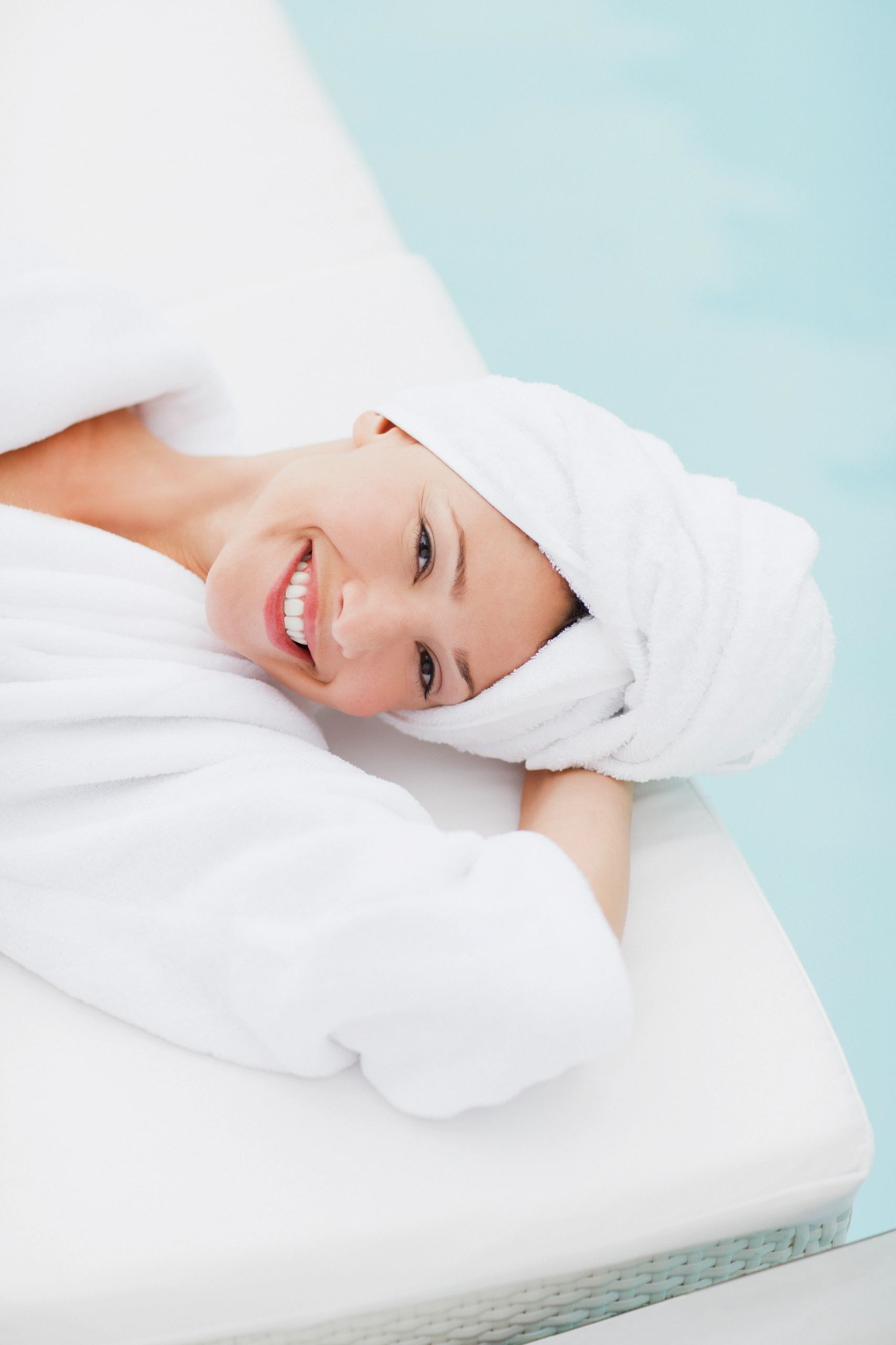 Spa guest resting by the pool in a robe